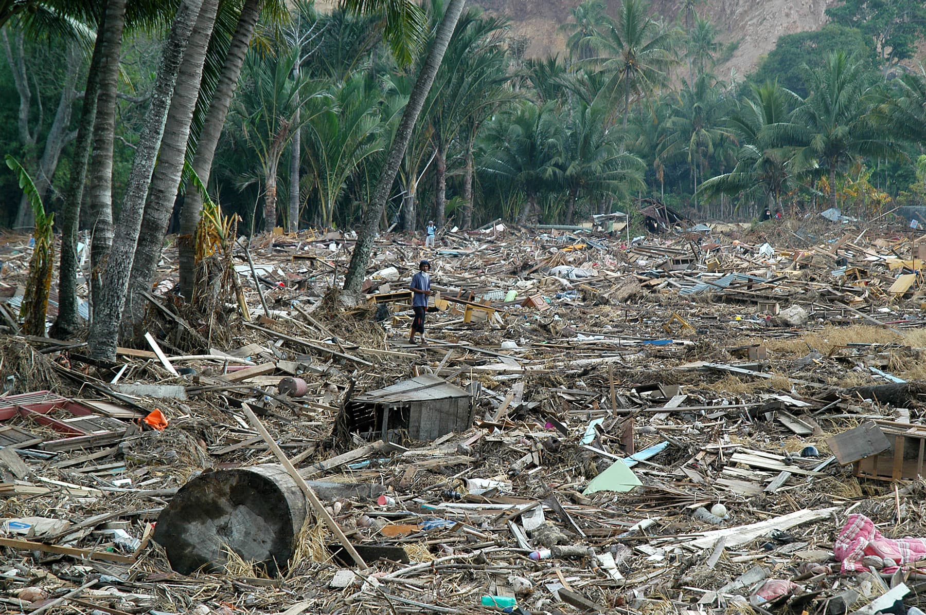 Survivors look for personal belongings among the remnants of destroyed homes following a tsunami in Aceh. Indonesia, 2004.