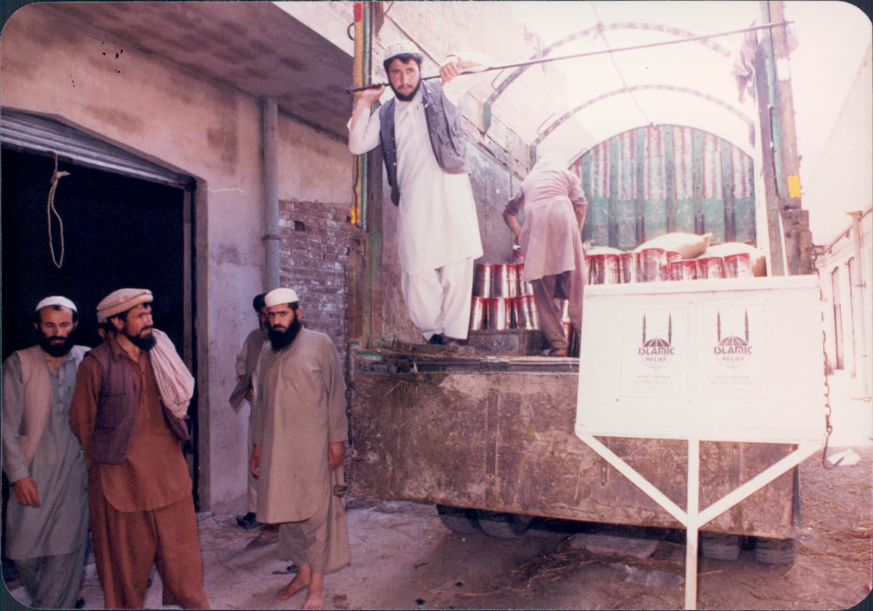 An Islamic Relief aid truck being unloaded. Afghanistan, 1989.