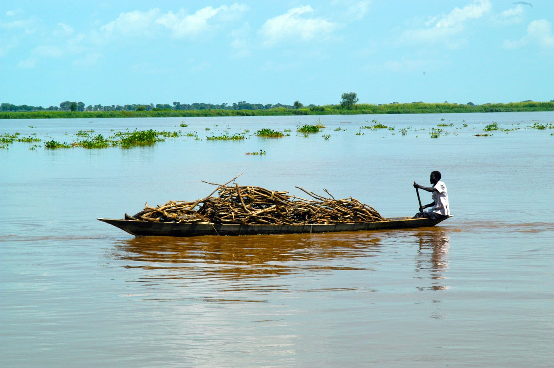 A man transports wood by boat in Darfur. Sudan, 2004.