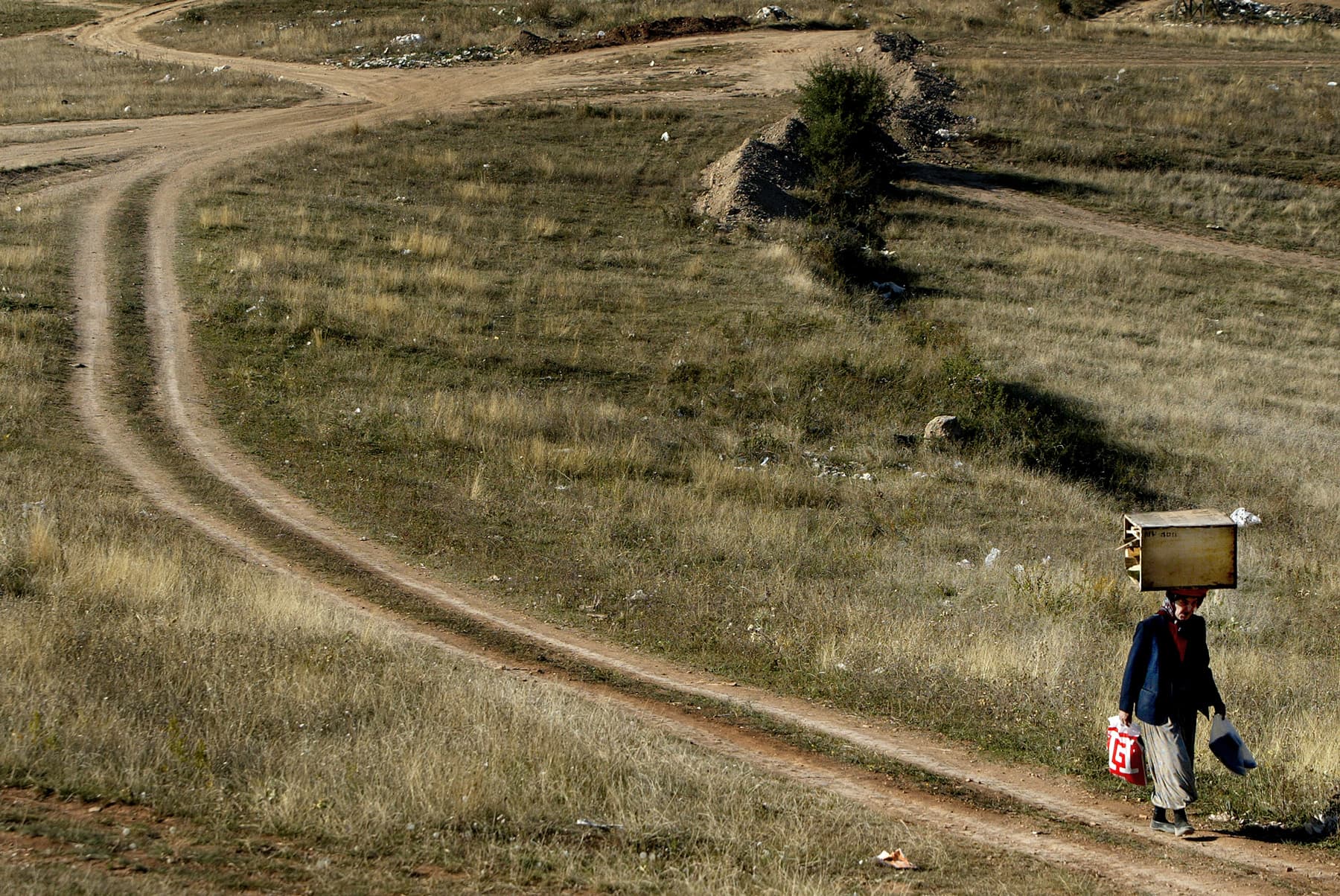 An older Bosnian woman carries a heavy load. Bosnia and Herzegovina, 2004
