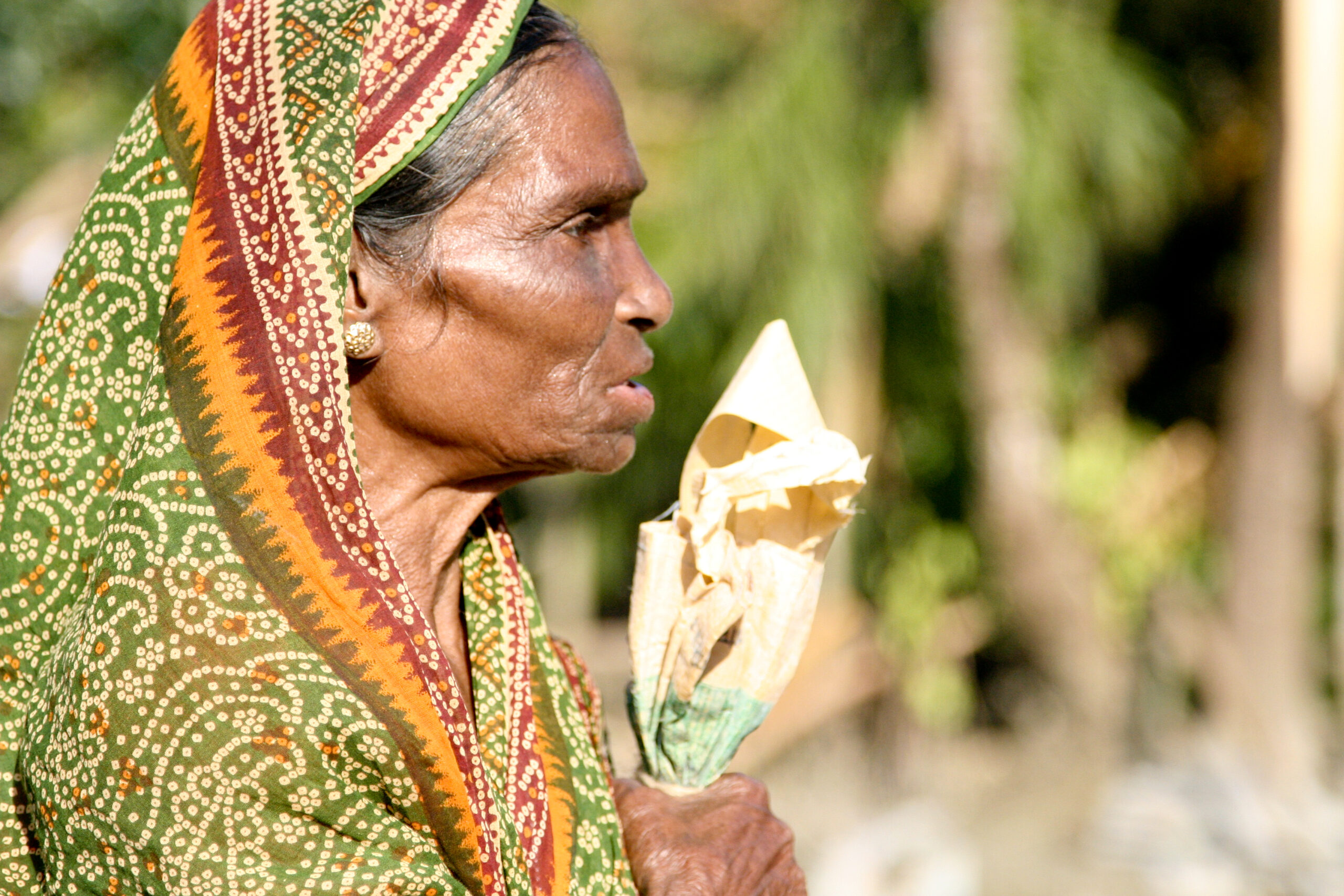 A woman carries a bag of aid from Islamic Relief following Cyclone Sidr. Bangladesh, 2007.