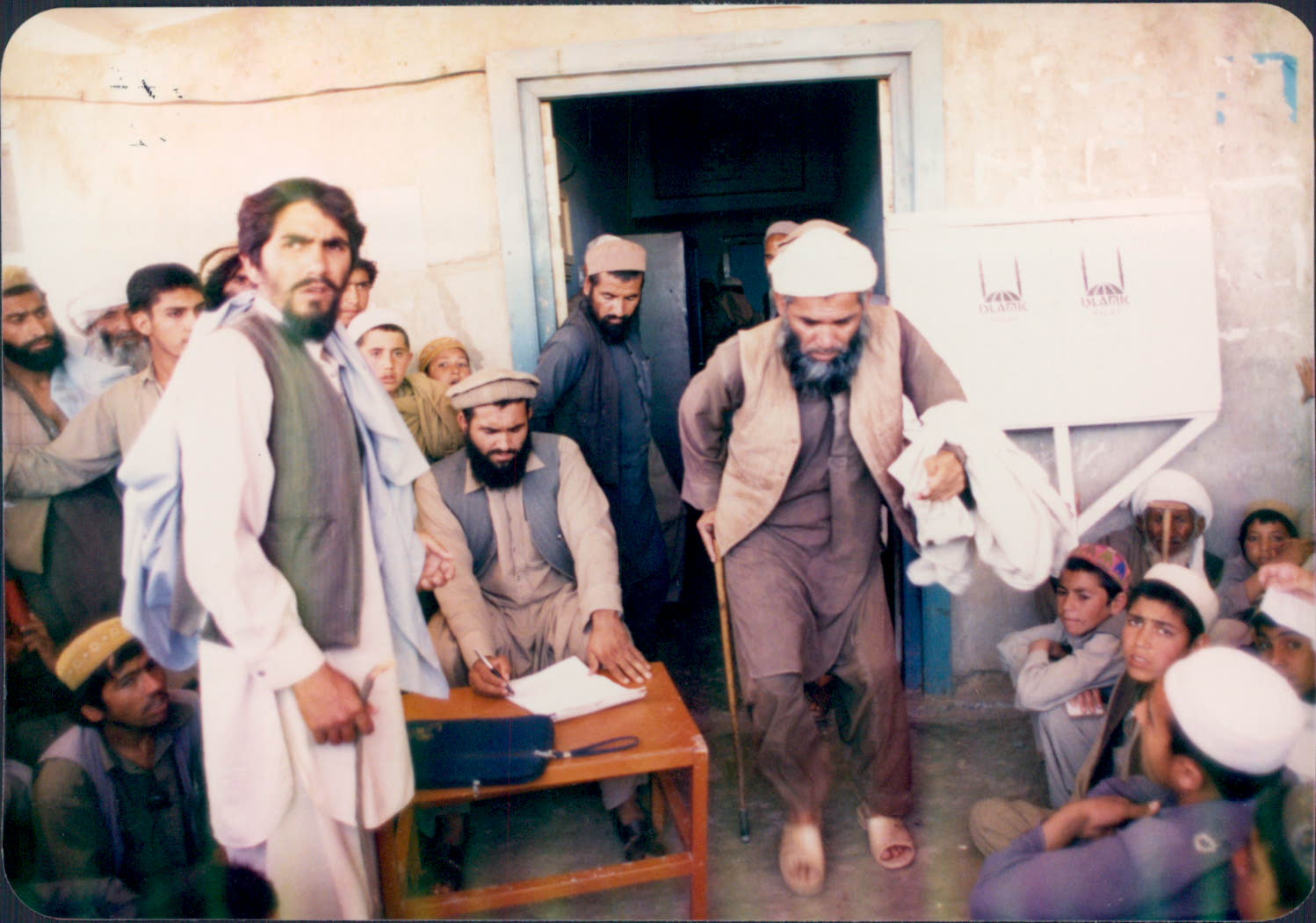 Men and boys wait to receive aid from Islamic Relief. Afghanistan, 1989.