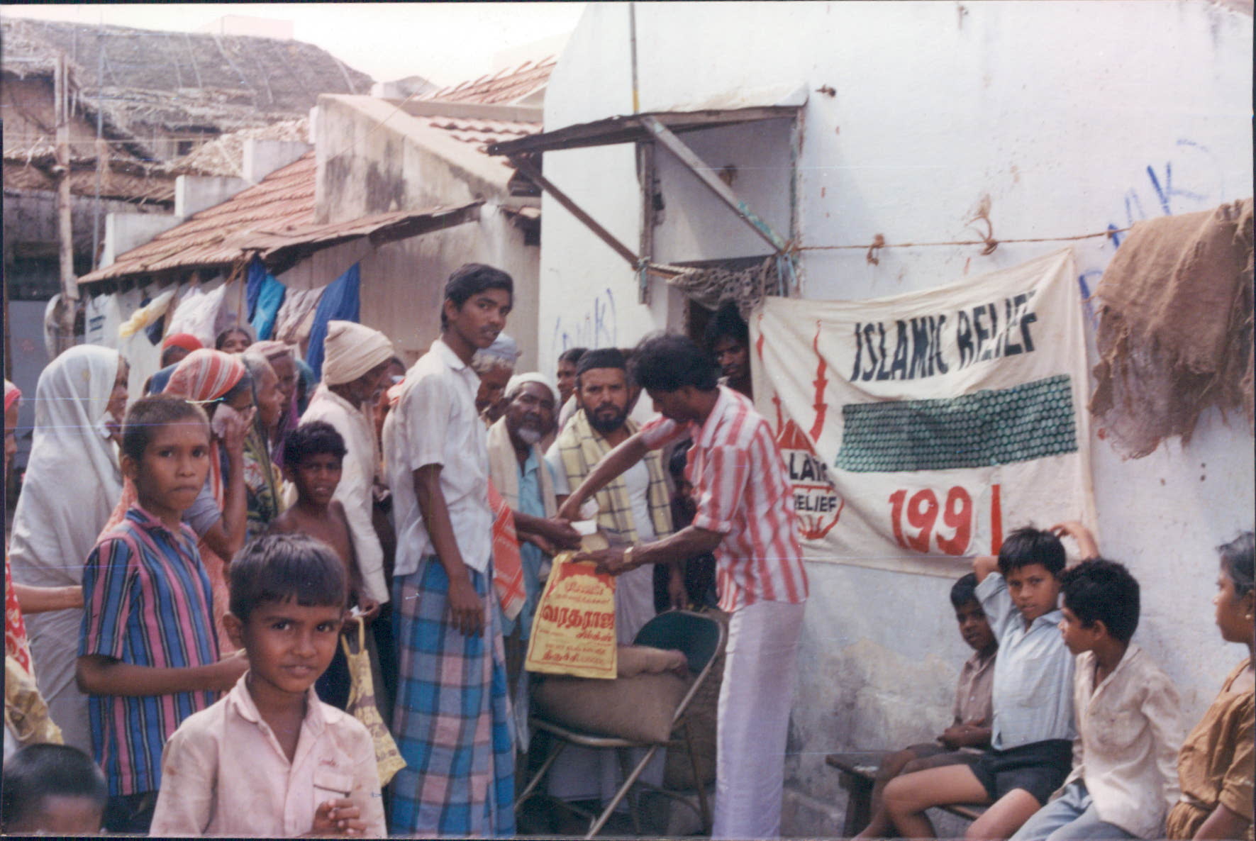 People wait to receive food and clothes from Islamic Relief. India, 1991.