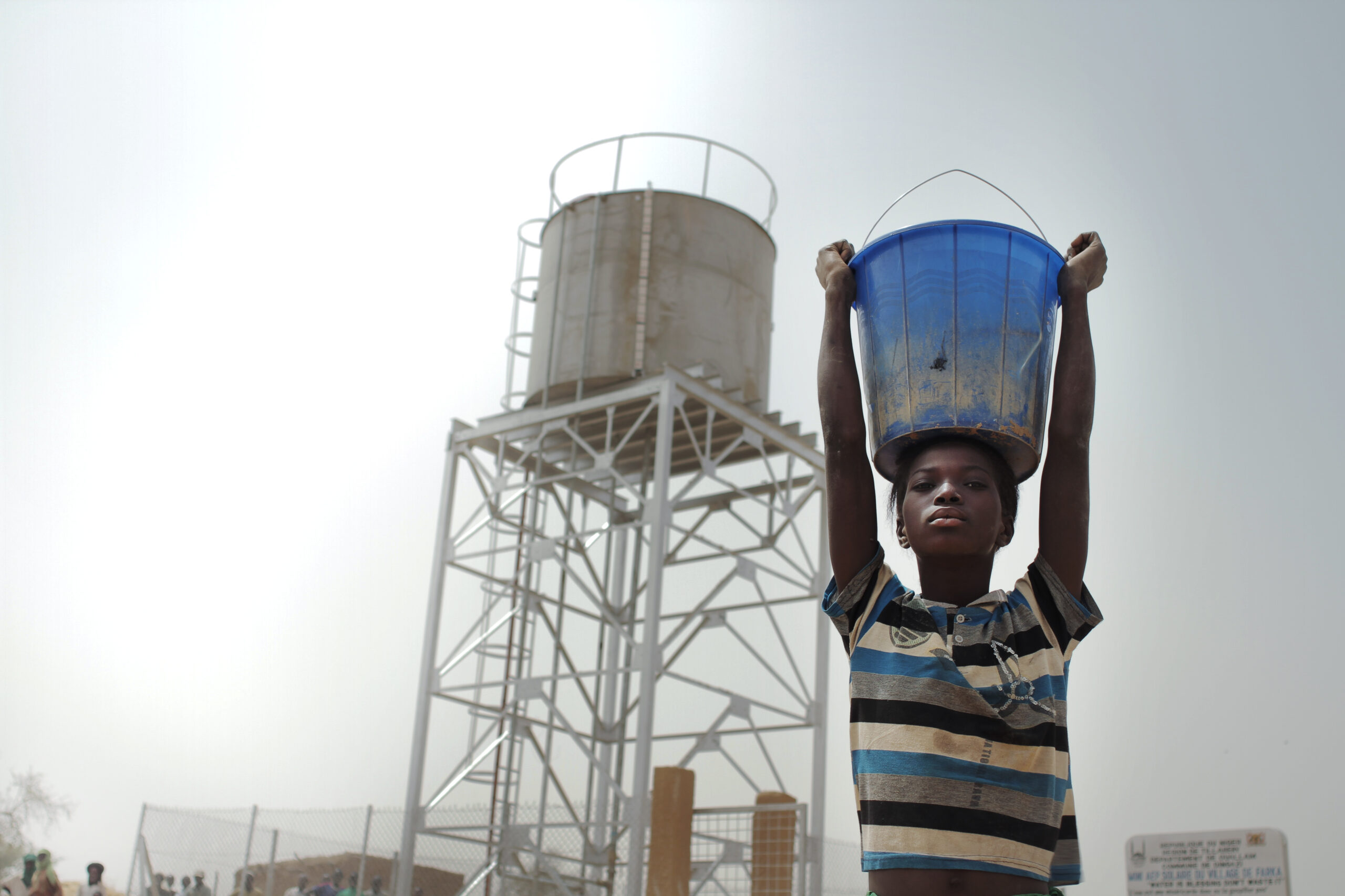 A young child holds a bucket of water collected from an Islamic Relief water point. Niger, 2012.