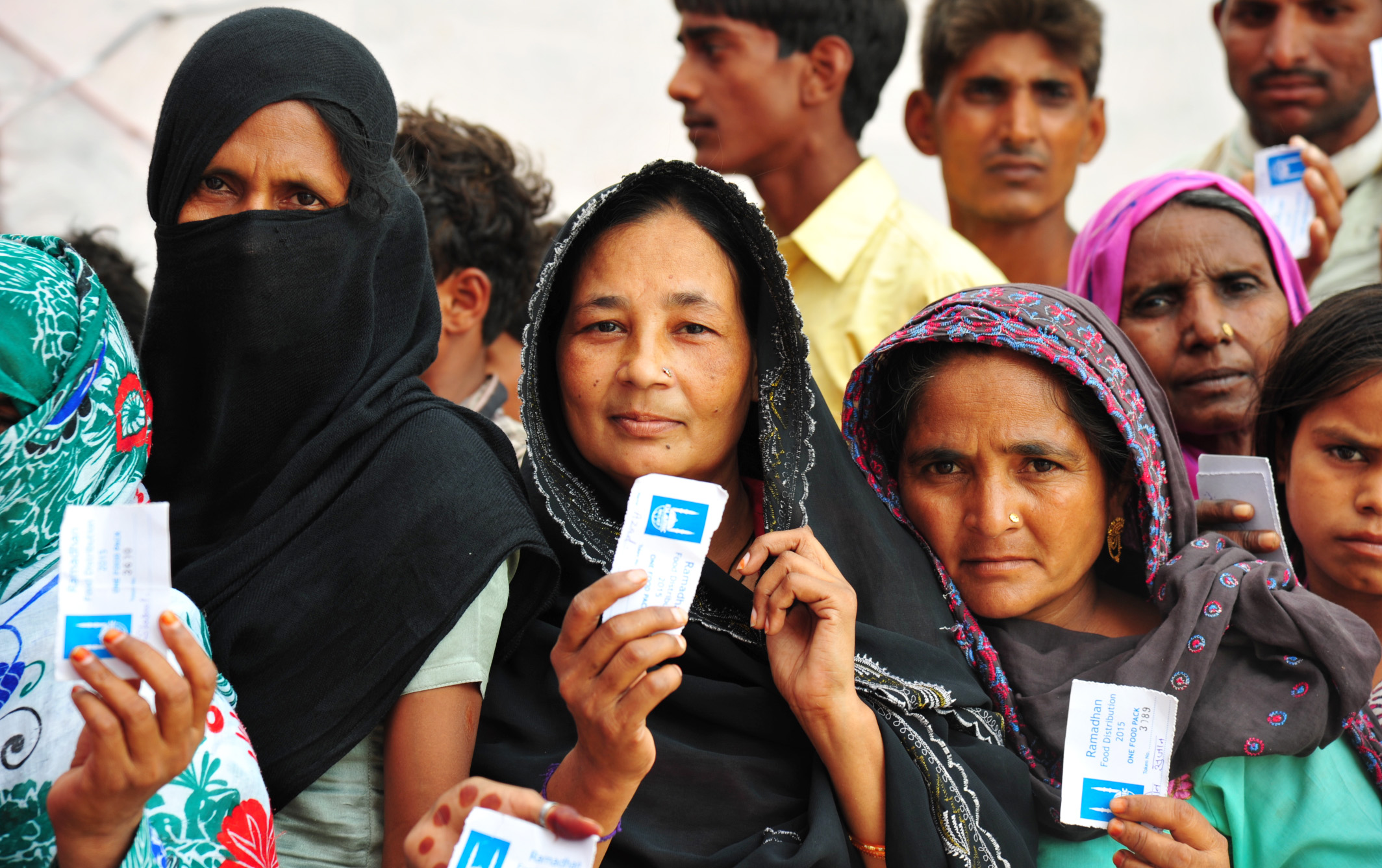 People wait to receive food from an Islamic Relief Ramadan distribution. India, 2015.

