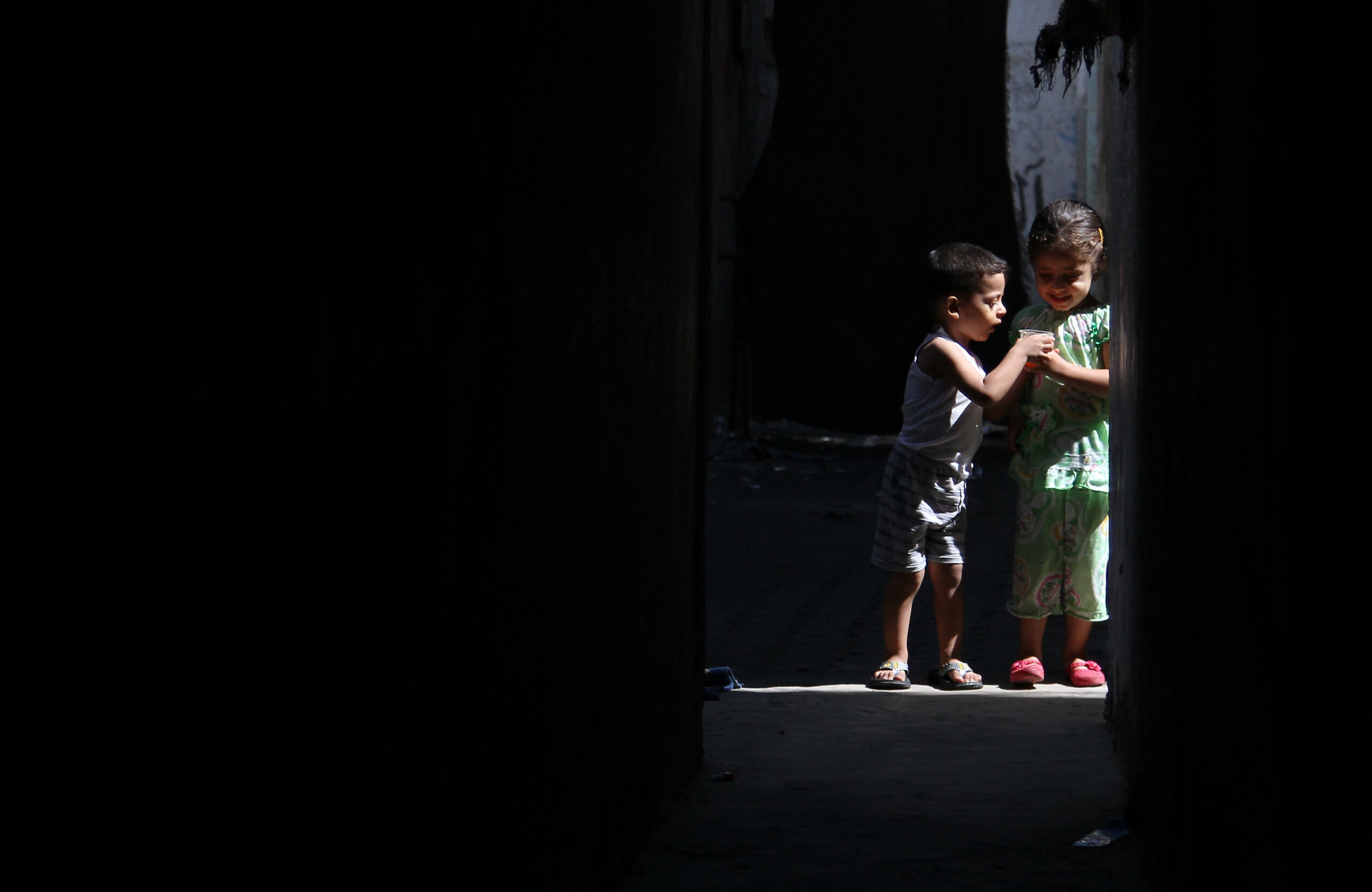 Two children stand in a doorway. Occupied Palestinian Territory, 2013.
