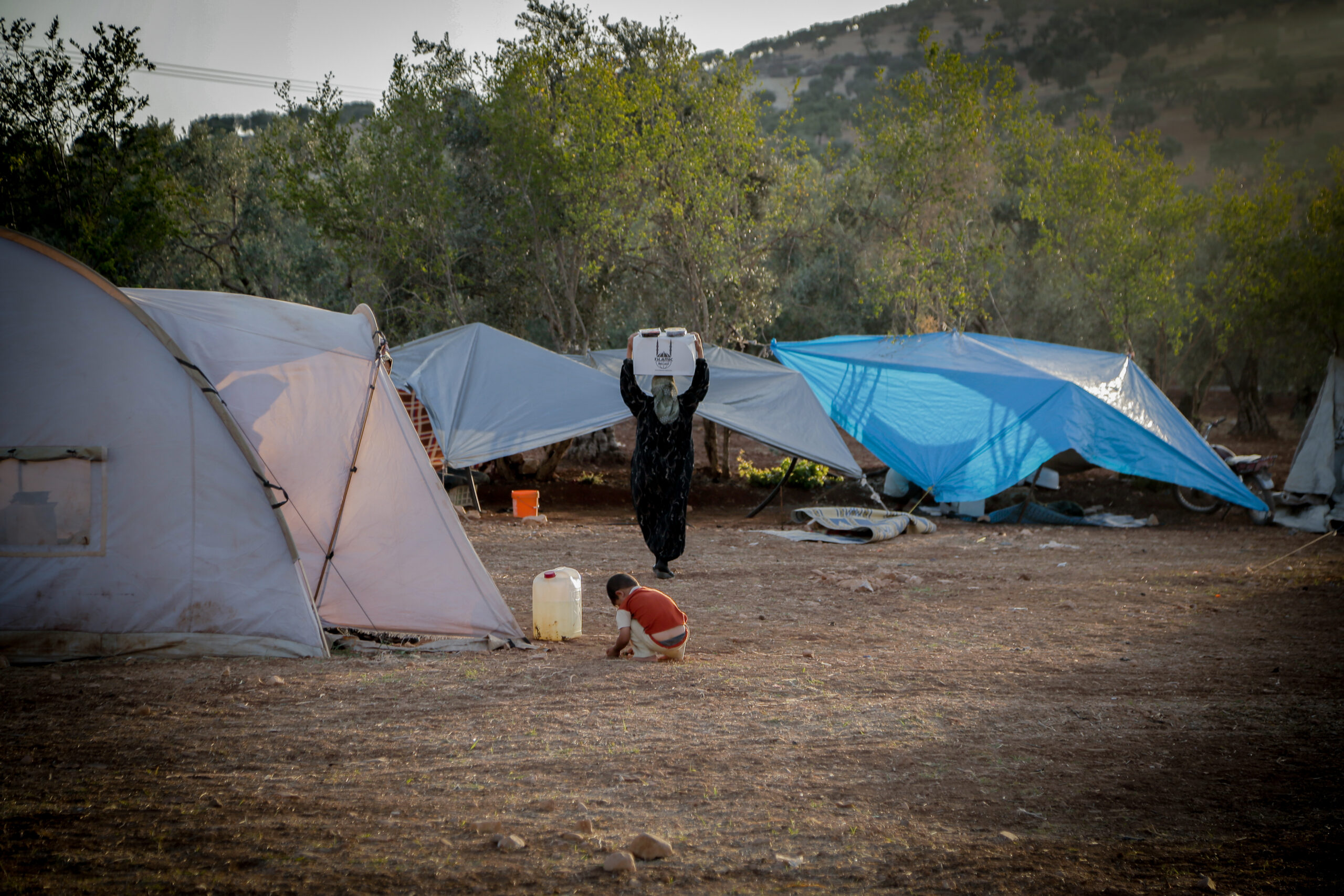 A woman returns home with food from an Islamic Relief Ramadan distribution. Syria, 2014.