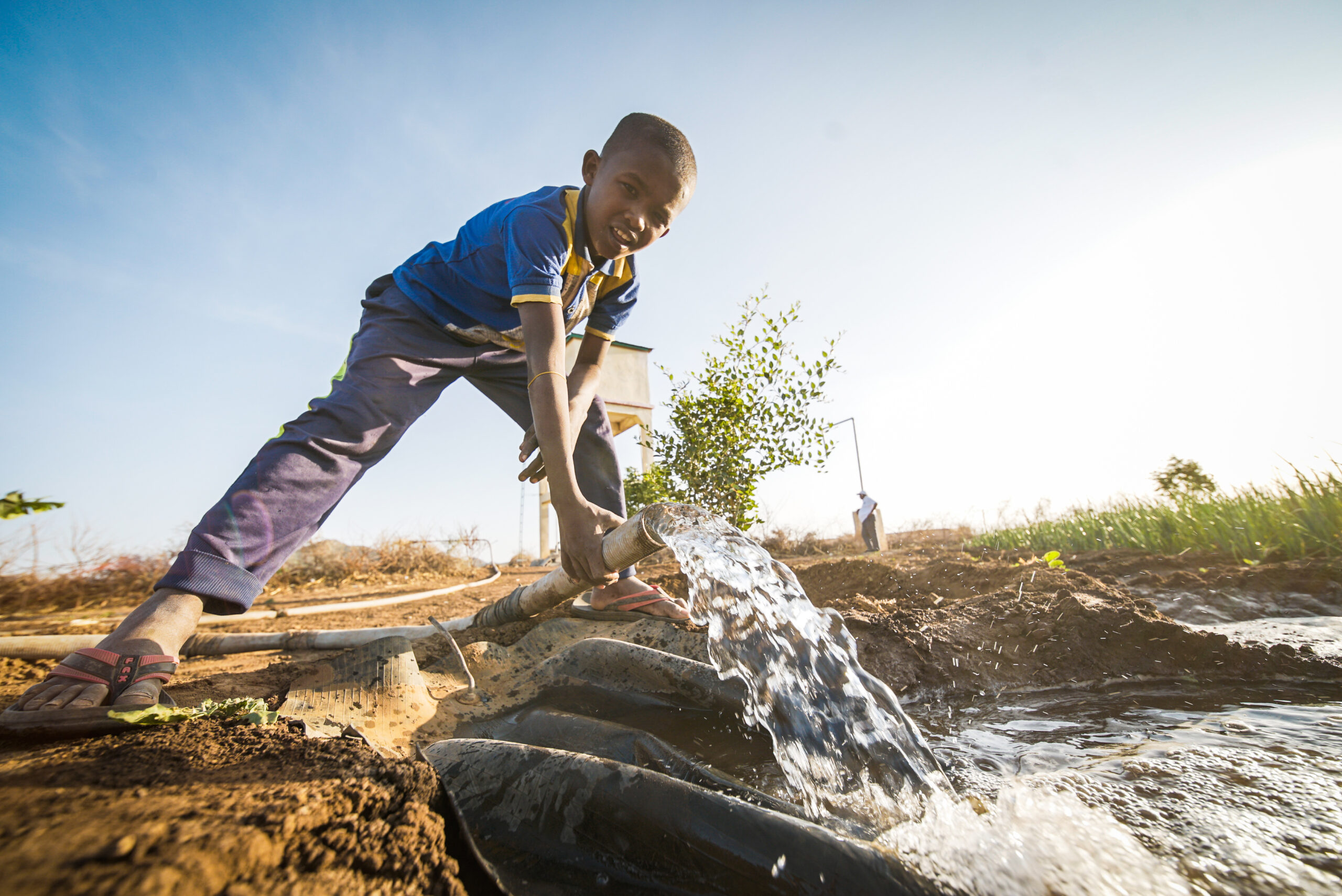 A boy holds a water pipe installed by Islamic Relief to bring clean water to nearly 19,000 people affected by drought. Somalia, 2015.