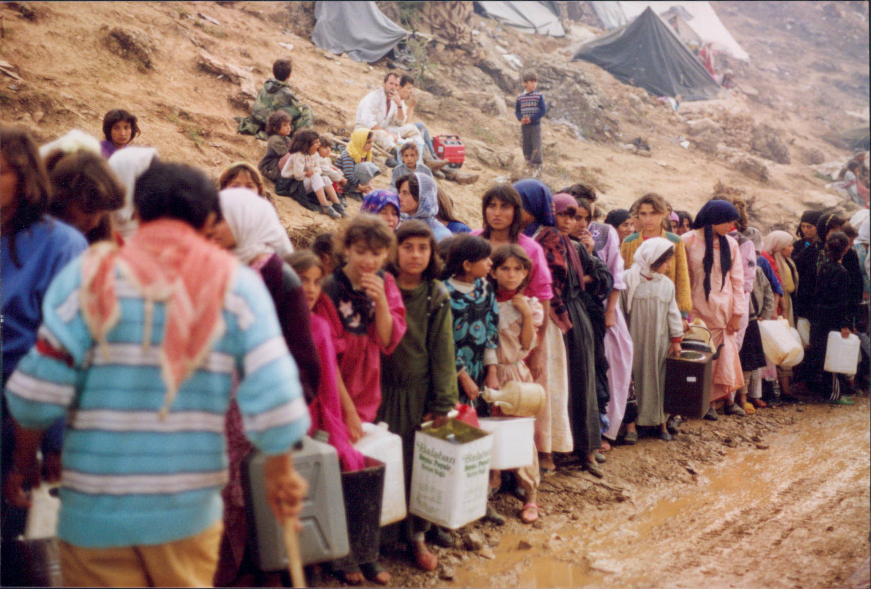 Refugees from Iraq wait to receive supplies from Islamic Relief at a makeshift camp alongside the Türkiye border. Türkiye, 1991.