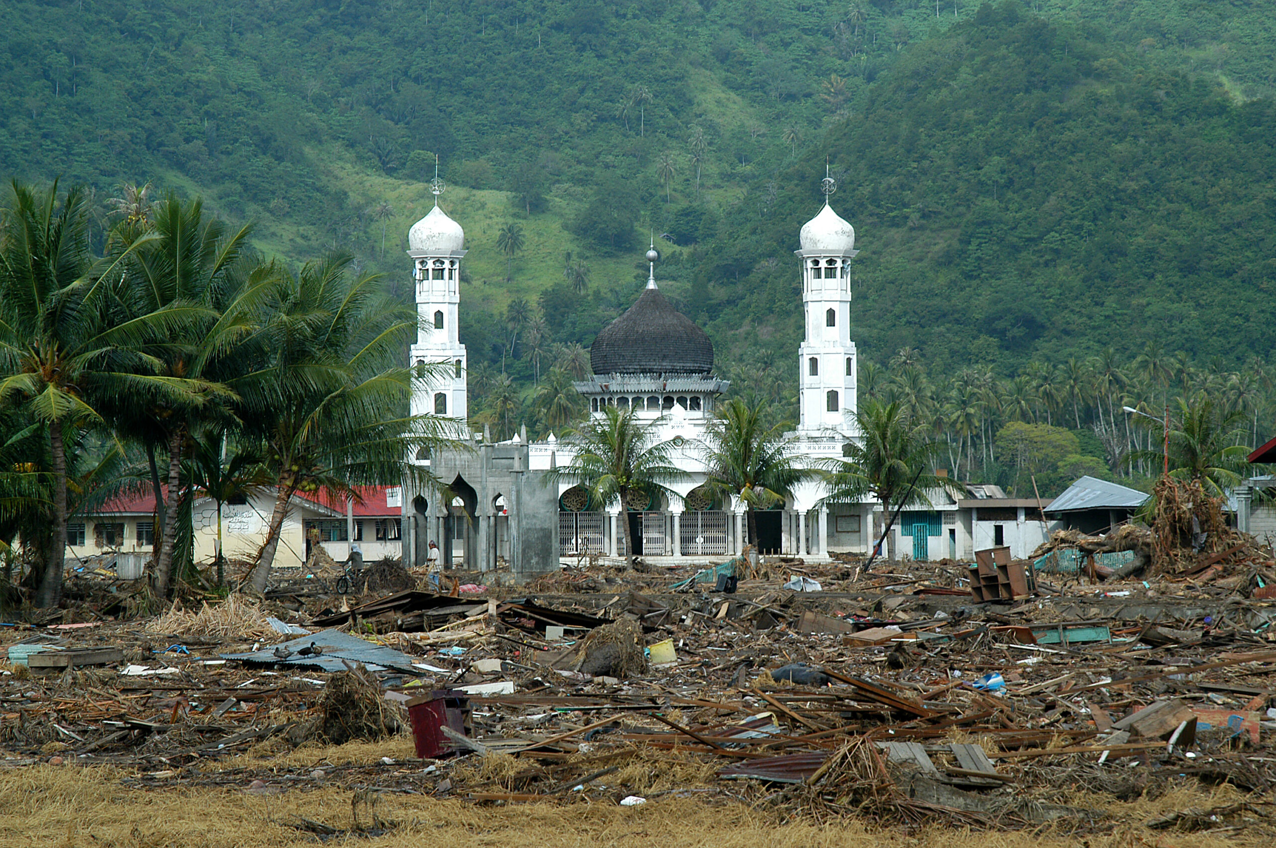 Survivors search among the ruins of buildings destroyed by a tsunami in Aceh. Indonesia, 2004.