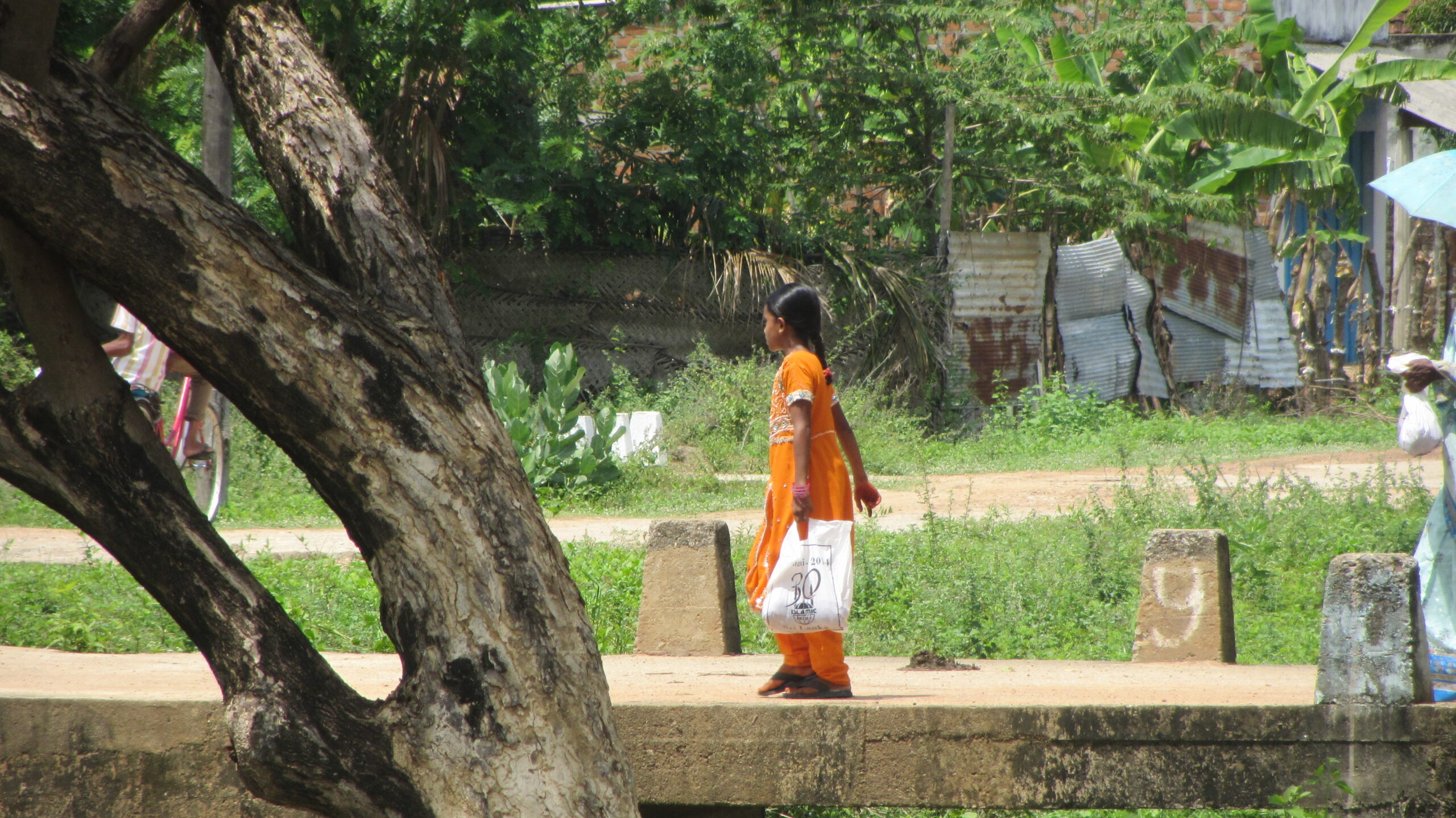 A young girl returning home with meat from an Islamic Relief qurbani distribution. Sri Lanka, 2014.