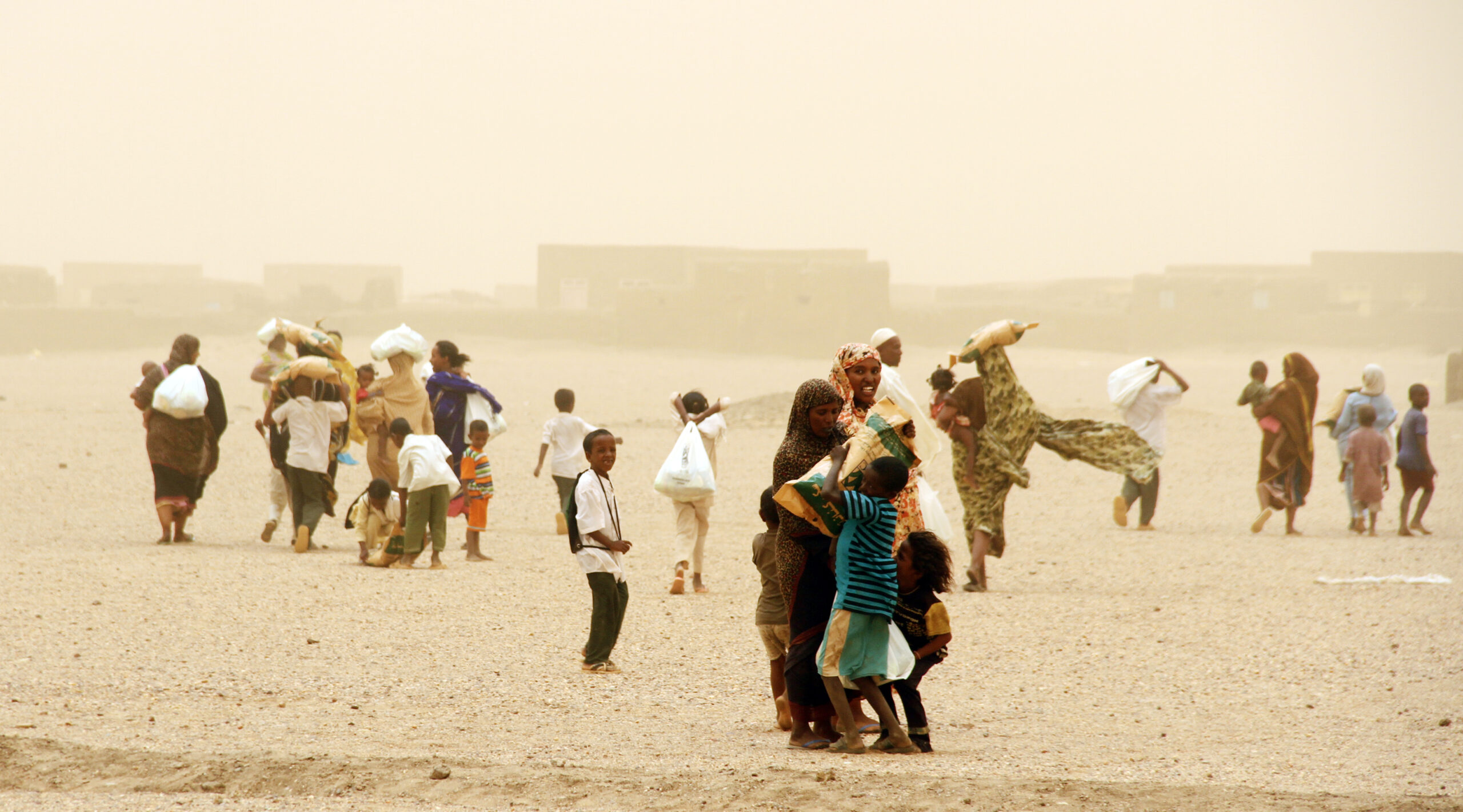 Families carry food home from an Islamic Relief food distribution. Sudan, 2014